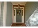 Welcoming front entry with a decorative wreath, brick trim, and overhead lighting fixture at 12124 Warwickshire Park, Raleigh, NC 27613