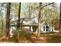 Single-story home featuring a bay window, mature trees, and spring flowers at 12124 Warwickshire Park, Raleigh, NC 27613