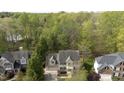 An aerial shot displays a lovely home nestled among a mature landscape near a serene body of water at 1335 Saint Andrews Dr, Mebane, NC 27302