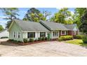 Charming single story home featuring brick and light green siding, complemented by a concrete driveway at 1410 Cross Link Rd, Raleigh, NC 27610