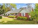 Cozy single story home showcasing a brick facade and light green siding, with neatly trimmed landscaping at 1410 Cross Link Rd, Raleigh, NC 27610