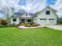 Inviting two-story farmhouse featuring a manicured lawn and three-car garage at 1506 Gormly Cir, Sanford, NC 27330