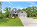 Beautiful two-story farmhouse boasts mature trees, manicured lawn and a three-car garage at 1506 Gormly Cir, Sanford, NC 27330
