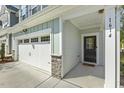 Townhouse entrance with a garage, number 1614 and a welcome mat at 1614 Brussels Drive Dr, Apex, NC 27502