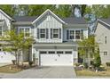 Townhouse showcasing a two-car garage, neutral siding and a well-manicured front yard at 1614 Brussels Drive Dr, Apex, NC 27502