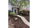 Charming brick home featuring a blue front door adorned with a wreath and surrounded by lush landscaping at 1640 Legendary Ln, Morrisville, NC 27560