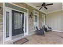 Inviting front porch featuring stone detailing, comfortable seating, and an ornate front door at 2000 Silverleaf Dr, Youngsville, NC 27596