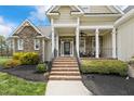 Welcoming front porch with stone accents, classic columns, and a charming seating area at 2000 Silverleaf Dr, Youngsville, NC 27596