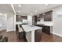 Modern kitchen with dark cabinets, quartz countertops, stainless steel appliances, and a kitchen island at 204 Concordia Woods Dr, Morrisville, NC 27560