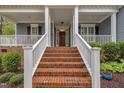Inviting front porch with brick steps, white railings, and a welcoming entrance at 212 Hein Dr, Clayton, NC 27527
