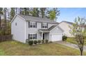 Well-kept two-story home with light gray siding, an attached garage, and green lawn at 2214 Bayswater Dr, Creedmoor, NC 27522