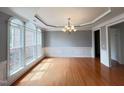 Dining room with hardwood floors, large windows, decorative trim, and chandelier at 222 Creststone Dr, Cary, NC 27519