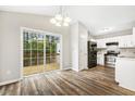 Eat-in kitchen with white cabinetry, stainless steel appliances, and sliding glass doors leading to the deck at 225 Lodestone Dr, Durham, NC 27703