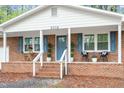 Inviting front porch with brick steps, white railings, and blue shutters at 2314 Clements Dr, Durham, NC 27704