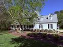 Beautifully landscaped home featuring a covered front porch, dormers, and a lush green lawn at 2385 Olde Spring Ct, Graham, NC 27253