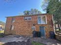 The back of the house with a door and windows, showing the brick exterior and some garbage cans at 24 Pine St, Franklinton, NC 27525