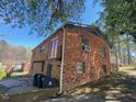 View of the side and back of a brick house showing several windows, gutters and the roof at 24 Pine St, Franklinton, NC 27525