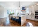 Modern kitchen features a large waterfall island, stainless steel appliances, and hardwood floors at 3000 Eden Harbor Ct, Raleigh, NC 27613