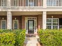 Close up of the front door with lush green bushes, brick walls and glass sidelights at 312 Alliance Cir, Cary, NC 27519