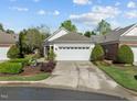 Well-maintained home featuring a pristine two-car garage, complemented by lush landscaping and a manicured lawn at 320 Easton Grey Loop, Cary, NC 27519