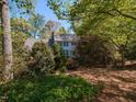 Charming two-story home with blue shutters surrounded by lush greenery and mature trees at 3320 Marblehead Ln, Raleigh, NC 27612
