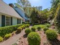 Landscaped front yard featuring green bushes lining a stone walkway leading to a light blue home at 3320 Marblehead Ln, Raleigh, NC 27612
