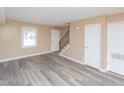 Bright living room features neutral walls, hardwood floors, a window, and staircase to the upper level at 4816 Blue Bird Ct # B, Raleigh, NC 27606
