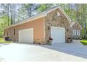 Spacious three-car garage with ample parking and a stone and siding exterior at 490 Shawnee Dr, Louisburg, NC 27549