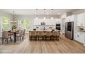 Bright, open kitchen featuring white cabinetry, stainless steel appliances, and a large island with a seating area at 50 Gadwall Ct, Zebulon, NC 27597
