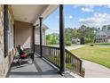 Charming covered front porch with dark support columns and railing, overlooking the landscaped front yard and street at 503 Fish Pond Ct, Rolesville, NC 27571