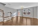 Spacious living room with hardwood floors, stairs, and natural light from large windows at 518 Retreat Ln, Wake Forest, NC 27587