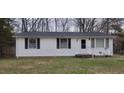 Close-up of a well-kept, one-story home's exterior with white siding, dark shutters, and a neatly trimmed lawn at 530 Broad Rd, Roxboro, NC 27573