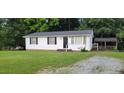 Quaint home with a well-maintained lawn and a detached covered structure in the backyard at 530 Broad Rd, Roxboro, NC 27573