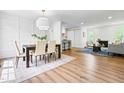 Bright dining area with modern lighting, white paneled wall, open to kitchen and living space at 5712 Wintergreen Dr, Raleigh, NC 27609