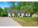 A cozy home with a well-maintained lawn and mature trees, complemented by a neat driveway at 5712 Wintergreen Dr, Raleigh, NC 27609