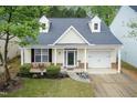 Aerial view of a yellow home boasting dormers, manicured lawn, and an attached garage at 59 Tuscarora Ln, Clayton, NC 27520