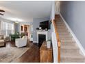 Spacious living room with hardwood floors, staircase, fireplace, and an open floor plan at 59 Tuscarora Ln, Clayton, NC 27520