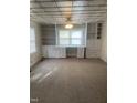 Spacious living room with carpet, custom shelving, and a decorative ceiling at 610 W Old Rd, Lillington, NC 27546