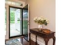 Welcoming entryway with dark wood floors, complemented by a decorative table and a vase of flowers at 65 N Wilders Ridge Way, Clayton, NC 27527