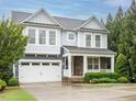 Charming two-story home featuring a two-car garage, stone accents, and lush front yard landscaping at 65 N Wilders Ridge Way, Clayton, NC 27527