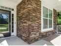Close-up of the front porch with stone pillars and a view of the front door and window at 65 N Wilders Ridge Way, Clayton, NC 27527