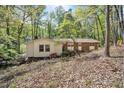 View of a charming single-story home with a brick facade, complemented by lush trees and greenery surrounding the property at 6709 Johnsdale Rd, Raleigh, NC 27615