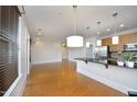 Bright living room with hardwood floors, modern lighting, and open kitchen concept at 700 Finsbury St # 306, Durham, NC 27703