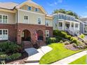 Charming brick townhome with arched entryway, surrounded by lush landscaping and a well-manicured lawn and inviting walkway at 714 Mordecai Towne Pl, Raleigh, NC 27604