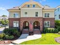Charming townhomes with matching brick facades and arched entryways, enhanced by lush landscaping and a well-manicured lawn at 714 Mordecai Towne Pl, Raleigh, NC 27604