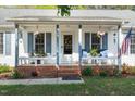 Close-up of the front porch with seating, plants, and an American flag, enhancing curb appeal at 807 Clean View Ct, Fuquay Varina, NC 27526