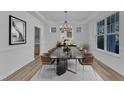This dining room features modern decor, including a chandelier, stylish table and chairs, and a large window at 858 Lake Artesia Ln, Fuquay Varina, NC 27526