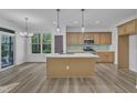 Spacious kitchen featuring a central island, modern appliances, light wood cabinets and stylish countertops at 858 Lake Artesia Ln, Fuquay Varina, NC 27526