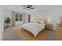 Relaxing main bedroom featuring tray ceiling, large window, and neutral decor at 858 Lake Artesia Ln, Fuquay Varina, NC 27526