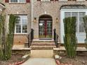 Beautiful brick home featuring a classic front door with decorative sidelights and manicured greenery at 9220 Meadow Mist Ct, Raleigh, NC 27617